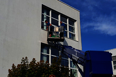 Zwei Gebäudereiniger auf einem Hubkran