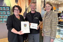 Übergabe des Bewilligungsbescheids (v. l.): LWV-Landesdirektorin Susanne Simmler, Geschäftsführer der CafeInklusiveKaffee GmbH Roland Braza und Bürgermeisterin Antje Runge. (Foto: CafeInklusiveKaffee GmbH) Gruppenfoto von der Bescheid-Übergabe mit Susanne Simmler, Roland Braza und Antje Runge