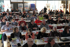 Veranstaltungsteilnehmer in Großenlüder (Foto: Sozialverband VdK Hessen-Thüringen) In einem großen Raum sitzen viele Personen. Vor ihnen auf den Tischen liegen Tagungsunterlagen.