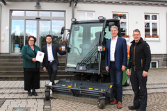 Gruppenfoto vor dem Aufsitzrasenmäher